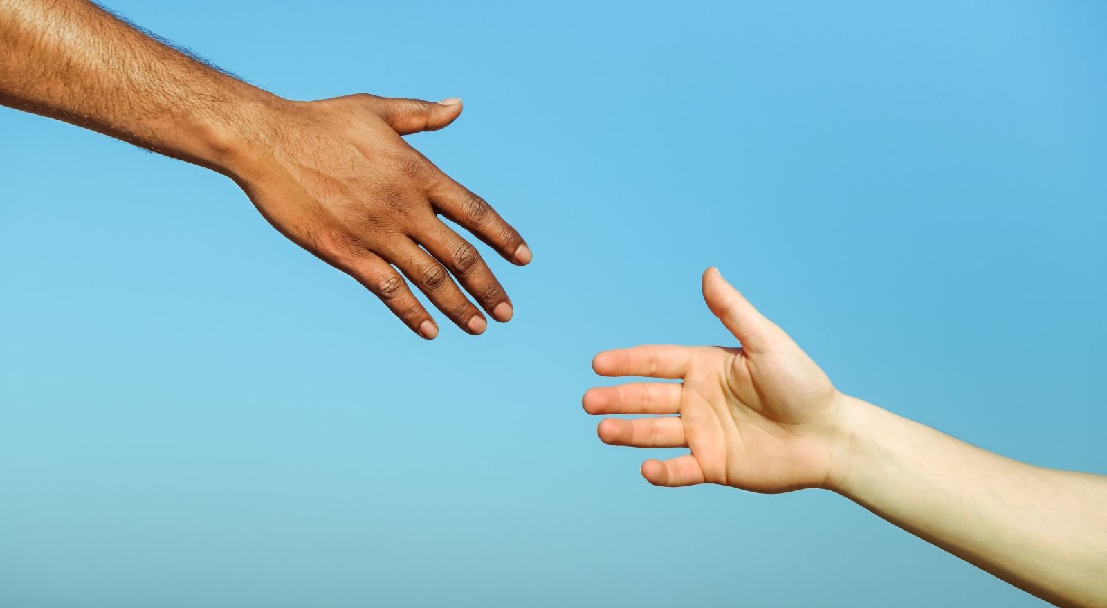 Black hand man helping white person Different skin color hands